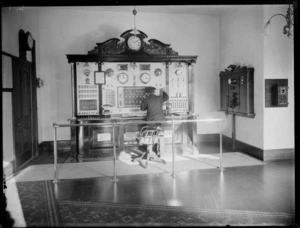 Fireman receiving a phone call on the Fire Station telephone switchboard, Central Christchurch