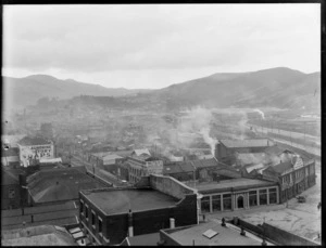View over rooftops to exhibition building on the right, next to Stone Printers, railway and Signal Hill beyond, Dunedin City