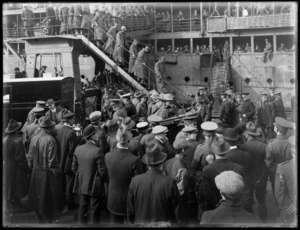World War I invalided soldiers arriving in Wellington, disembarking troop ship down stairs to waiting ambulance and car, with senior officers and people on wharf looking on