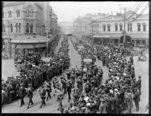 Welcome home parade for World War I returned servicemen, High Street, Christchurch City, including brass band, also showing businesses premises for jeweller J A Robb and tailor Ellis & Co