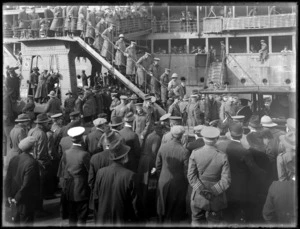 World War I invalided soldiers arriving in Wellington, disembarking troop ship down stairs and into a waiting car, with waiting senior officers and people on wharf looking on