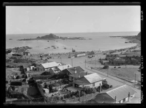 View over Island Bay, Wellington, showing houses, V Barnao's grocery and fruit store, the beach, and over to Tapiteranga Island