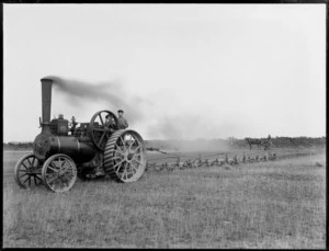 A tillage and furrow plough traction engine, with two men on board, probably Christchurch area