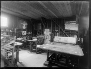 Interior of a printing shop, including press and work tables