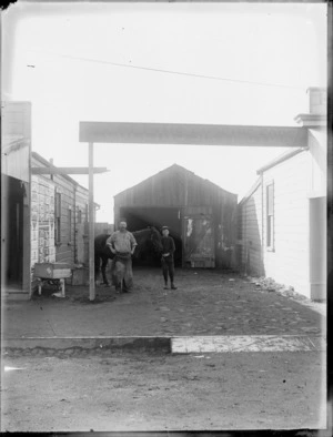 W Collins blacksmith, and boy standing with horse in front of shop, Stratford, Taranaki