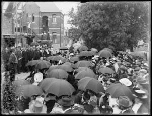 Crowd at the laying of the foundation stone for Christchurch Hospital, showing some holding umbrellas