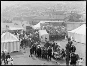 Fair in the railyards, Lyttelton Railway Station, Canterbury, including 'The Smallest Horse in the World' sign on the tent in the background