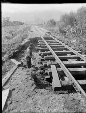 An unidentified man doing maintenance work on railway tracks, location unidentified