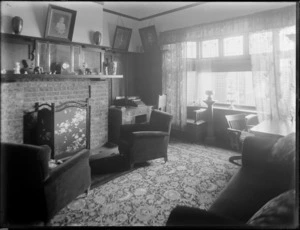 A writing room scene at [Hotel Ambassadors, Manchester Street, Christchurch?], with desks and typewriter, lounge suite, and prints on the walls