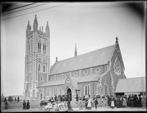 Saint Mary's Anglican Church, Timaru, with crowds of people and a motor car out the front