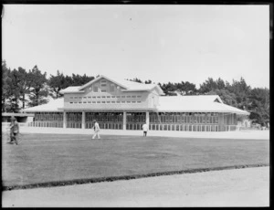 Horse racing, exterior of the totalisator building, with men in the foreground, location unidentified