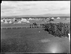 Mounted Riflemen in camp, [Trentham Racecourse?], with tents and a wooden dwelling in the background