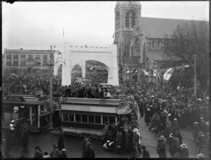 Scene in Christchurch during the visit of the Prince of Wales, showing crowds at Cathedral Square and Bridge of Remembrance structures