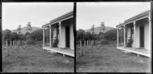 Woman, wearing a hat and sitting on the verandah of a house, Catlins, Otago