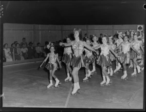 Unidentified team of roller skating girls in costume, on a rink in Lower Hutt