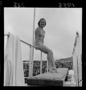 Professional diver Pat Keller McCormick (from the United States of America) poses on the three meter springboard in front of a crowd, [Te Aro Baths, Wellington?], New Zealand