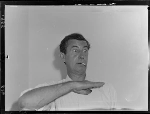 Australian actor Chips Rafferty gesticulating and smoking a cigarette