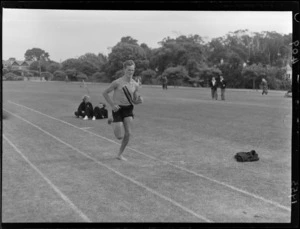 An unidentified runner competes in a running race, Dewar Sheild Athletics, Hutt Park, Gracefield, Lower Hutt City, Wellington Region