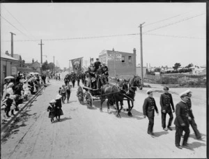 Timaru Voluntary Fire Brigade on a horse-drawn cart in the parade, on an unidentified street which includes the business premises of W Healey Sanitary plumber and gasfitter, Timaru, to celebrate the coronation of George V