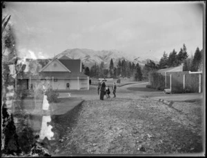 A view of Hanmer Spring Sanatorium, North Canterbury, showing an unidentified family walking in the grounds