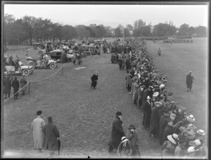 Crowds of people at Hagley Park, Christchurch, watching military brass bands, also motor cars on the left