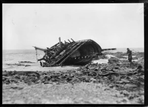 A man standing near a wrecked ship on the shoreline, Clyde, Otago