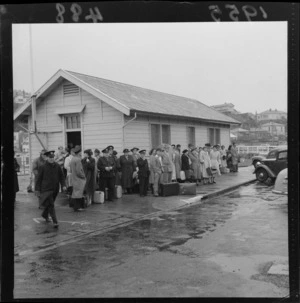 Passengers wait beside a building on Clyde Quay, Wellington, after disembarking from the ferry, Maori