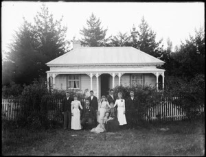 Family posing in front of house