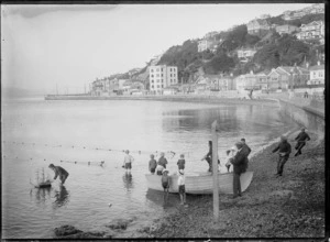Creator unknown: Photograph of a scene at Oriental Bay, Wellington, including a boy with a model ship, and fishermen