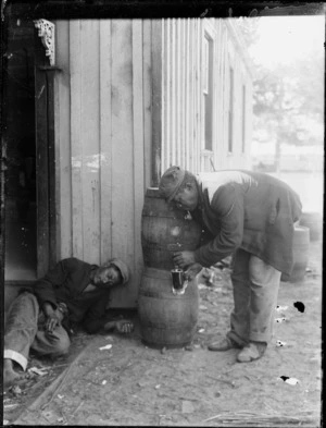 Maori man filling a glass from a keg