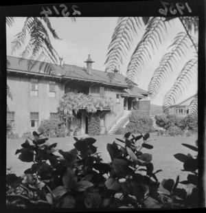 Across the lawn view from the bushes, Wisteria vine growing on the veranda, private family residence, unknow location