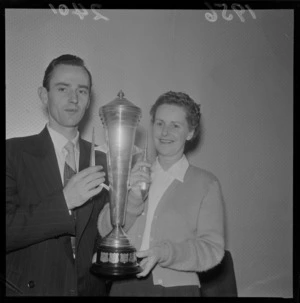 Ballroom dancers Mr CW Giles-Paine and Mrs BM Kirkwood, holding a trophy that they have won