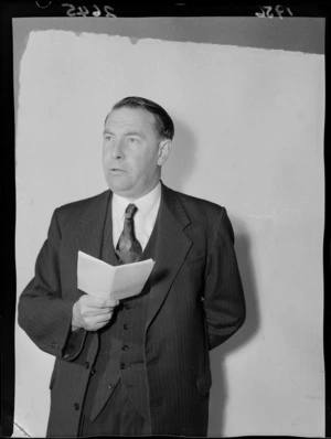 Campaign portrait of Francis (Frank) Joseph Kitts, 1956 mayoral candidate for Wellington, reading from a pamphlet