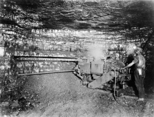 Man working machinery down a coal mine