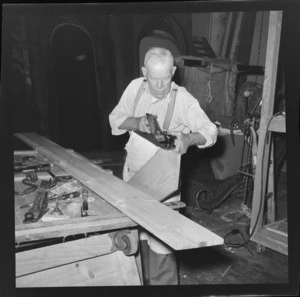 An unidentified man building a theatre set for a New Zealand Players Theatre Trust production