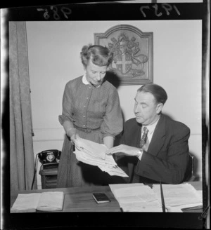 Wellington Mayor Frank Kitts speaking to an unidentified woman [his secretary?] at his desk