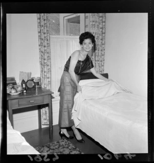 Unidentified Thai dental nurse making a bed, including bedside table with apples and tin of Edmonds custard powder, location unknown