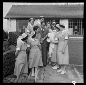The Royal New Zealand Plunket Society, Karitane Home, [parents?] and baby, with a group of nurses, [Island Bay, Wellington?]