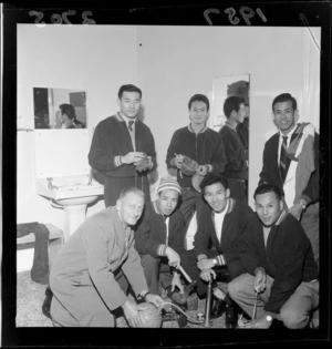 Chinese soccer players with their coach in the changing room pumping the match ball