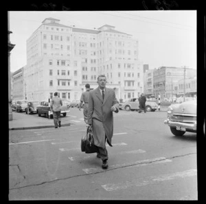 Mr Norman Reid crossing the road at the intersection of Mercer Street and Victoria Street, Wellington Civic Chambers in background