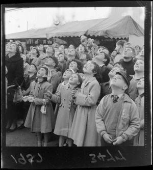 Children gazing at Elfy Morell's acrobat, showing children with their winter coats