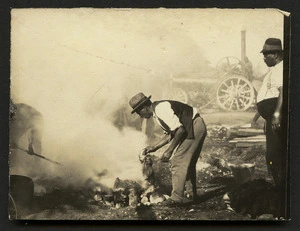 Men tending a hangi pit