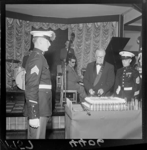 The American Ambassador (Francis H Russell) cutting the cake at the anniversary of the United States Marine Corps