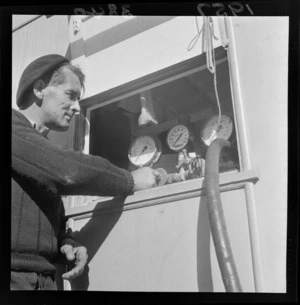 Diver with a compressor and pipe, Wellington wharf