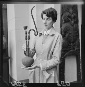 Staff member, Mrs Nadia Johnston, with a hookah pipe in the Dominion Museum, Wellington