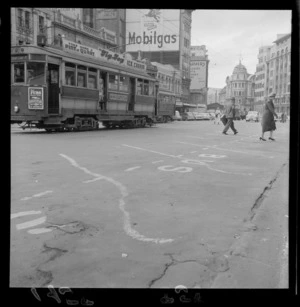 Tram passing by a cracked part of the paving on Lambton Quay, Wellington, where the buses stop and start