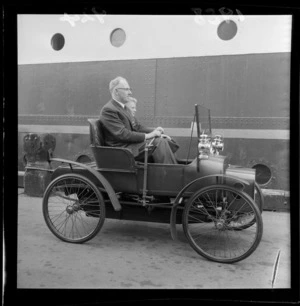 Mr E M Delaney driving a 1902 Crestmobile being driven on wharf at Wellington, going to Picton on ship Rangitira