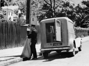 Postman clearing a mail-box on Hobson Street, Wellington