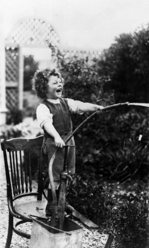 Young child holding a water hose