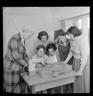 Residents in the Crippled Children's Society home in Miramar, Wellington, watching a woman using a sewing machine